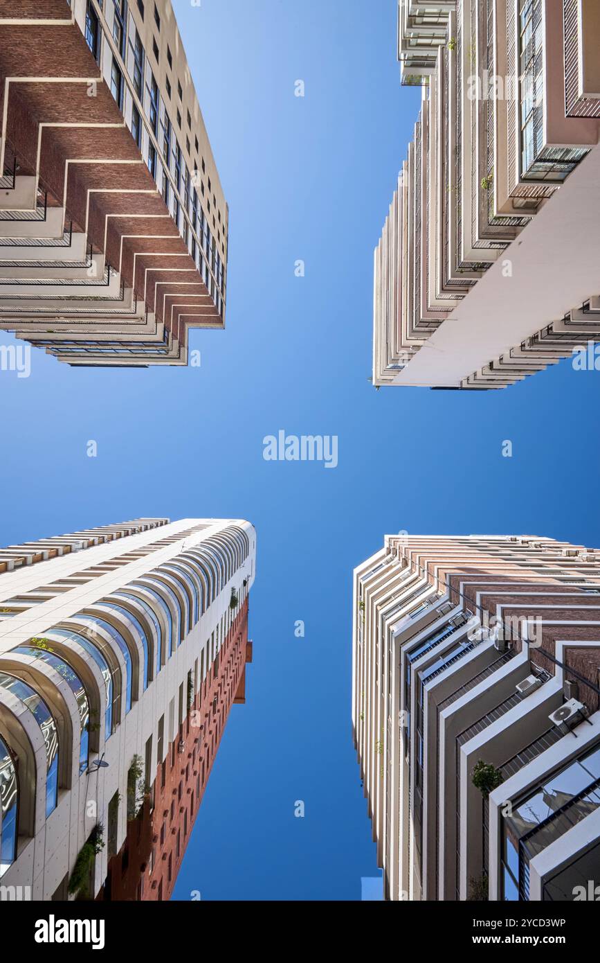 Foto di Nadir di 4 edifici residenziali alti sotto un cielo limpido. Ogni edificio ha il proprio design. L'immagine evidenzia la ripetizione dei pavimenti Foto Stock