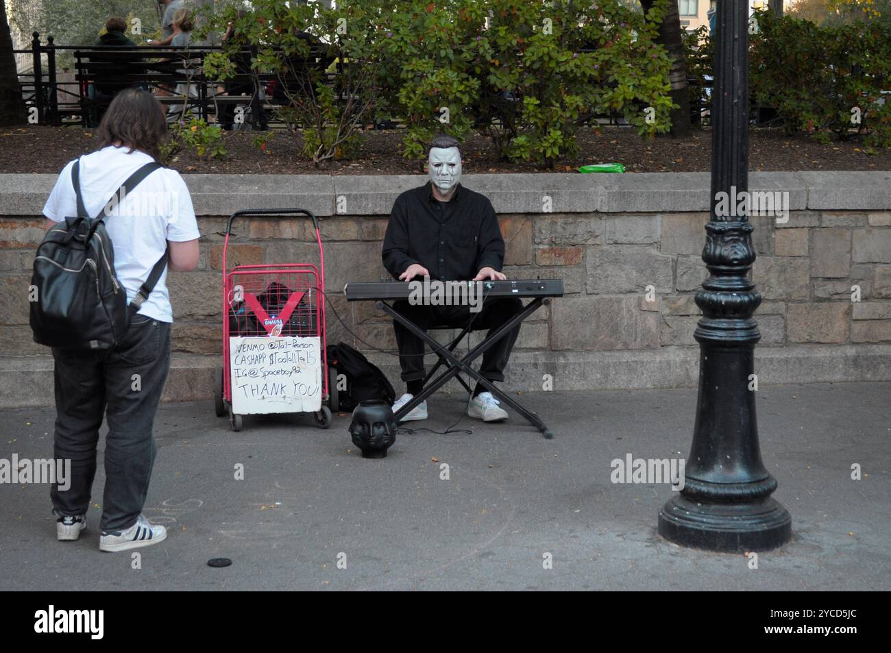 Una persona vestita da Michael Myers della serie di film horror di Halloween suona il pianoforte a Union Square, Manhattan, New York City. Foto Stock