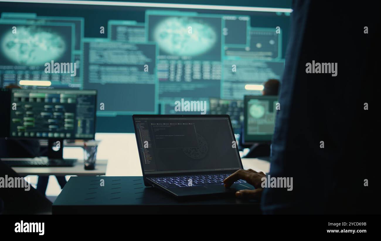 Hacker governativi al lavoro monitorano le minacce informatiche in un'agenzia high tech, implementando misure di sicurezza informatica. L'esperto IT si concentra sull'importanza della privacy online e della protezione da malware. Telecamera B.. Foto Stock