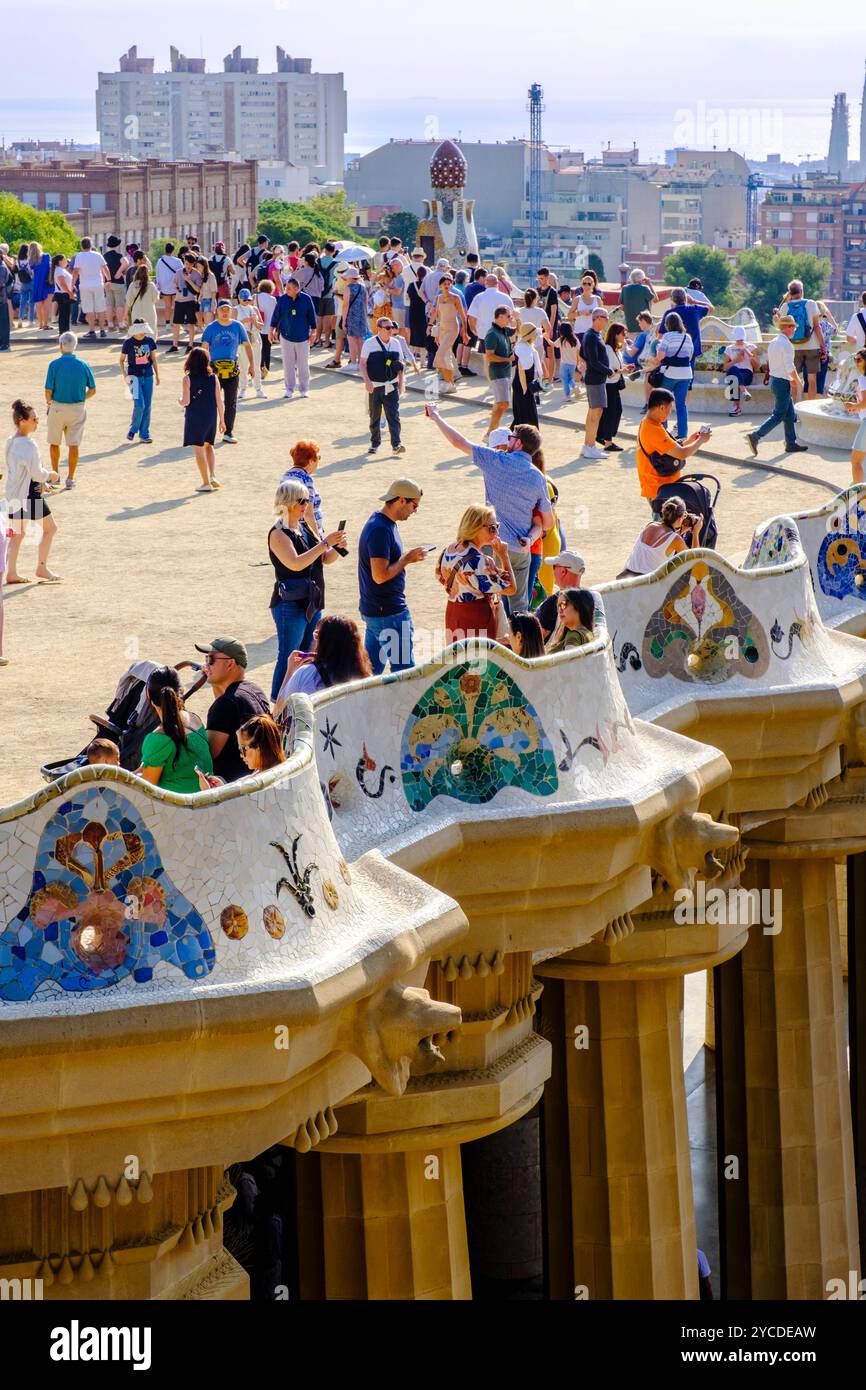 Turismo di massa, turismo eccessivo, Parc Güell mosaici, piastrelle, Antoni Gaudí, colonne della camera Ipostyle, terrazza affollata di turisti, Barcellona Spagna Europa Foto Stock
