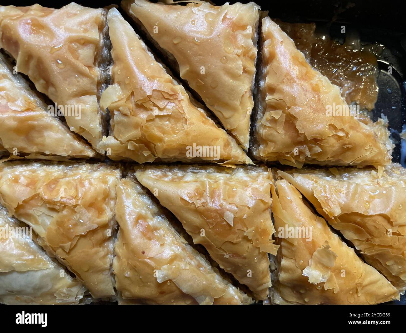 Primo piano di fette triangolari di Baklava appena sfornate - Immagine stock catturata con smartphone