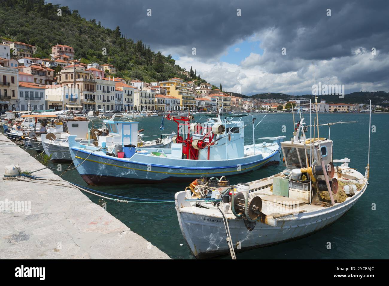 Imbarcazioni ormeggiate in un molo di una città costiera sotto un cielo leggermente nuvoloso con colline verdi sullo sfondo, porto, Gythio, mani, Laconia, Peloponneso, Foto Stock