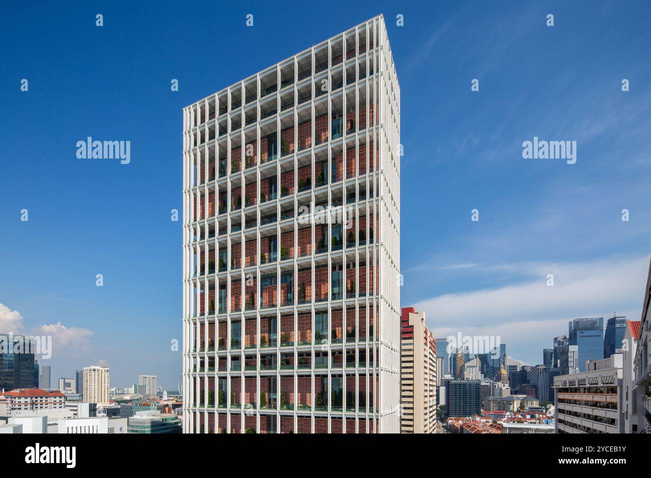 Grattacielo architettonico della Corte degli Stati di Singapore. Contro il cielo blu e il quartiere urbano. Gli alberi sono piantati all'interno dell'edificio. Foto Stock
