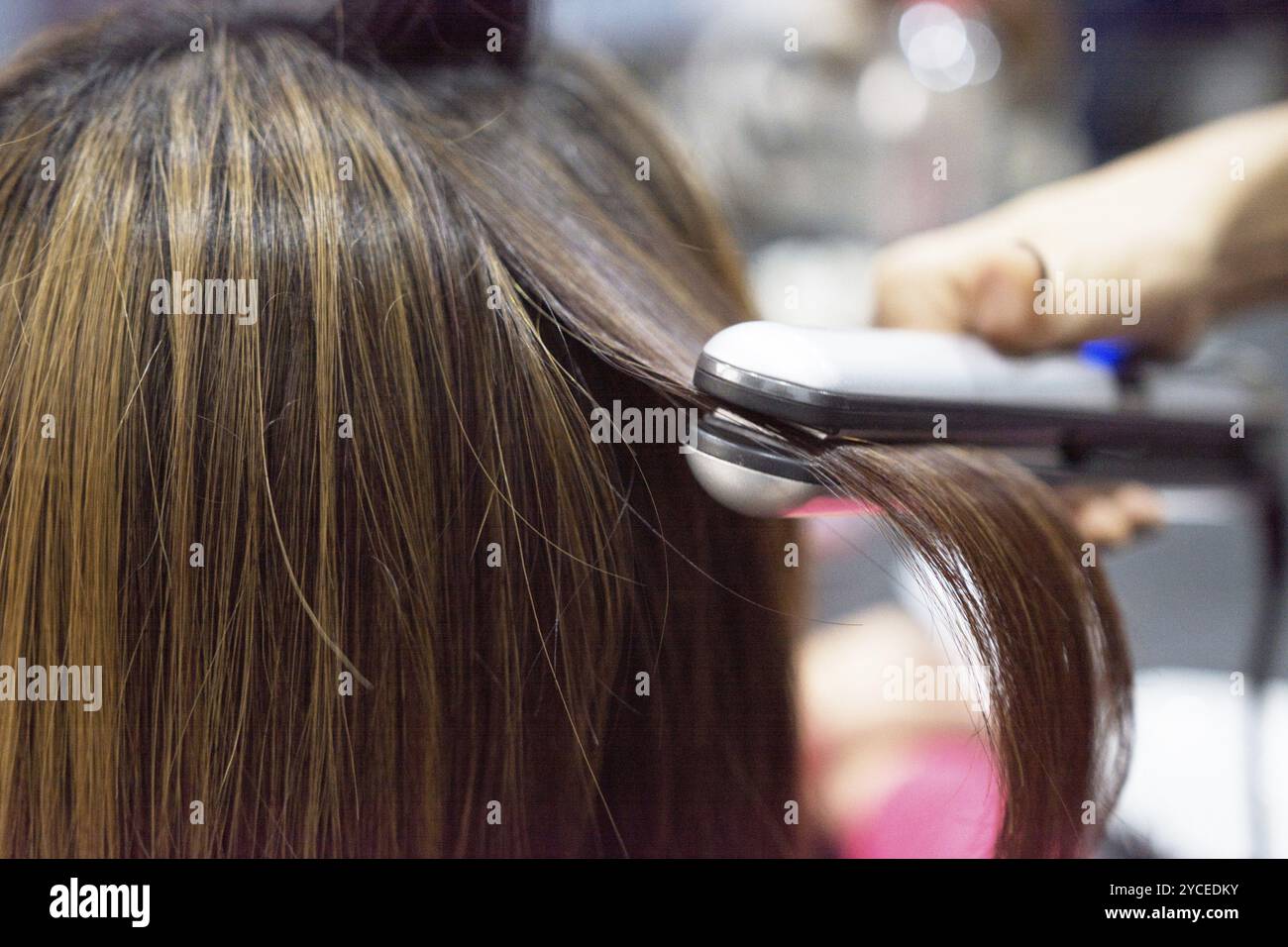 Parrucchiere utilizzando capelli su i capelli castani donna Foto Stock