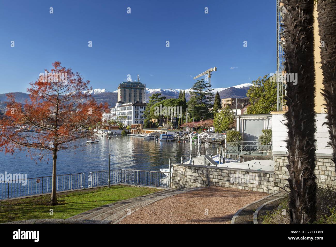 Idilliaco panorama invernale della città di Lugano, dietro le montagne innevate (Alpi svizzere) . Vicino agli edifici sulle rive del Lago di Lugano, eccellente Foto Stock