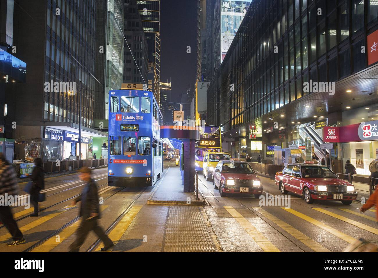 Persone irriconoscibili, in movimento, sfocate. Hongkong, c'è gente che tira! A due piani, tram a sinistra, autobus a destra Foto Stock