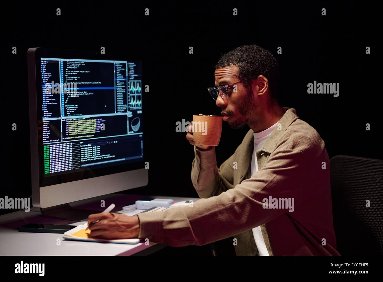 Focalizzarsi sulla codifica con caffè alla scrivania Foto Stock