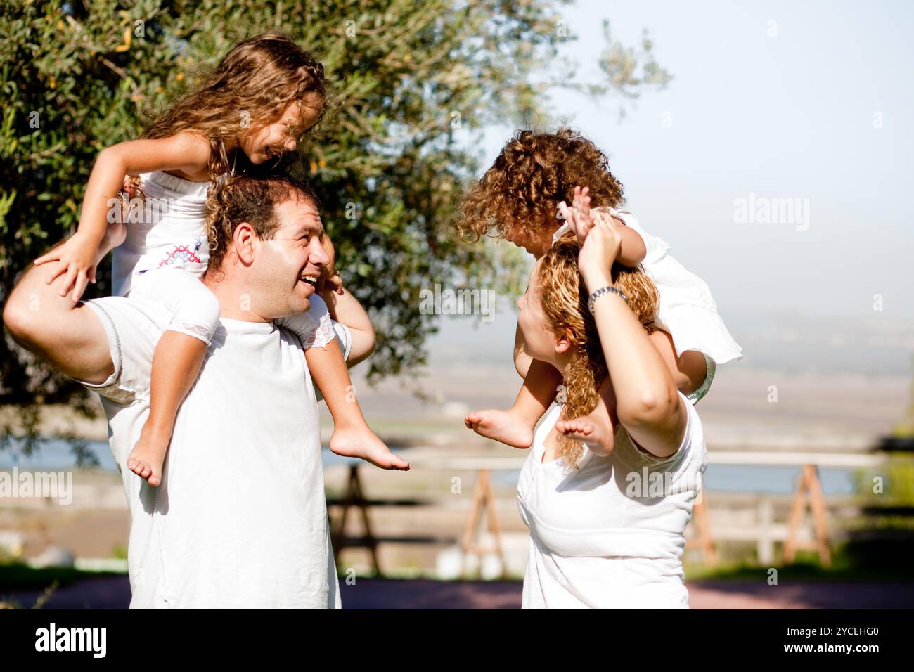 Bambini divertirsi e giocare sulle loro spalle i genitori Foto Stock