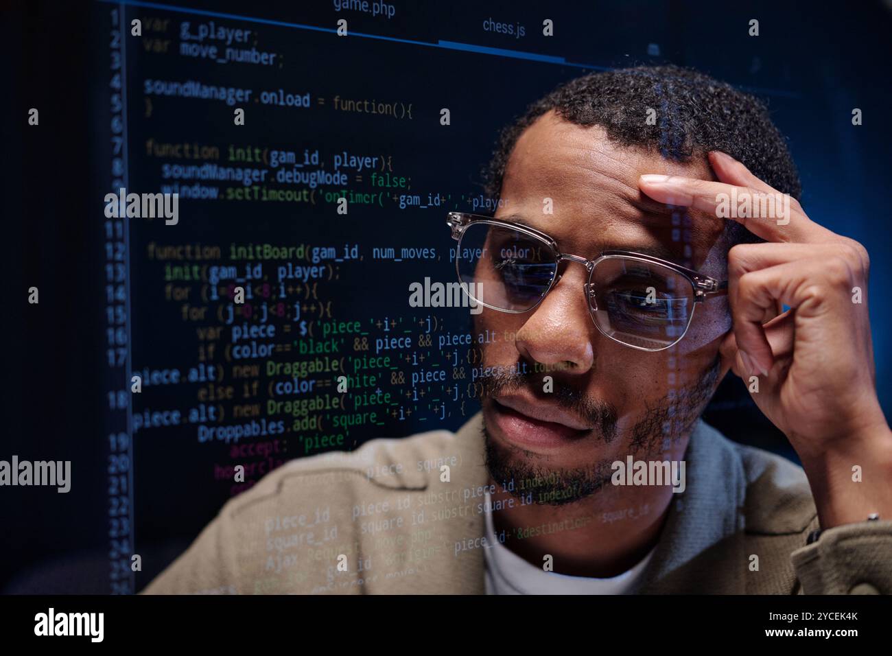 Analisi del codice sullo schermo del computer con espressione grave Foto Stock