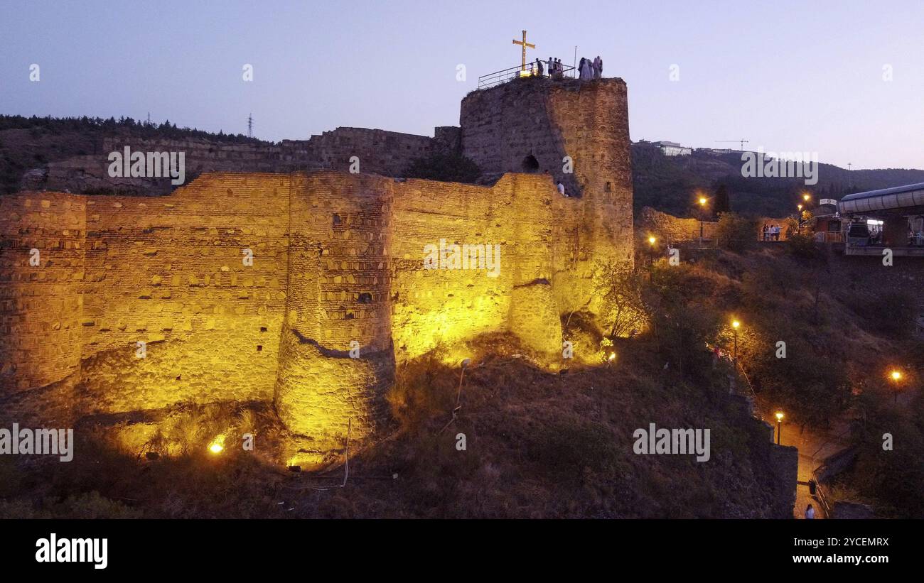 Fortezza illuminata di Natikala al tramonto di Tbilisi. Persone irriconoscibili a Tbilisi Foto Stock