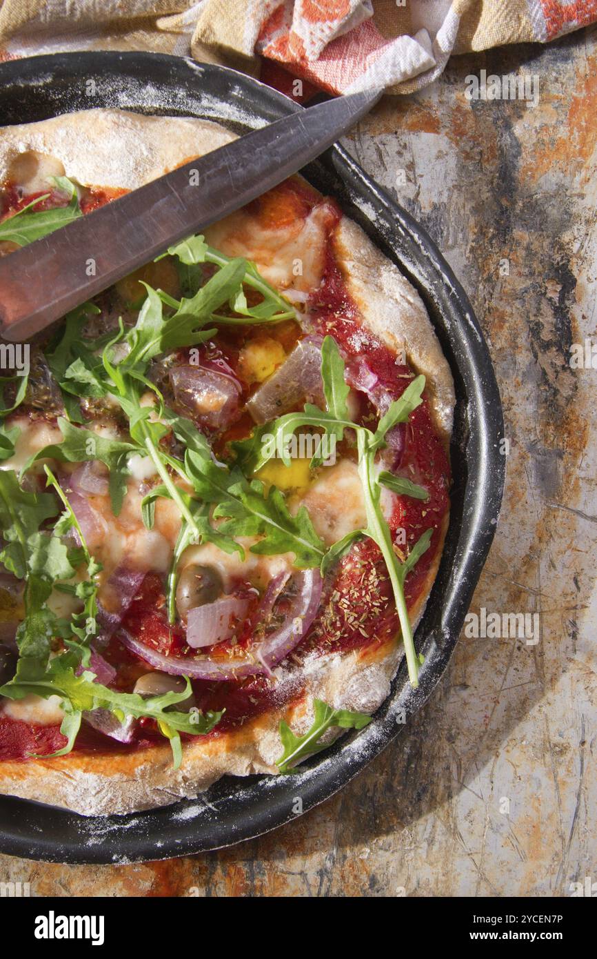 Base per pizza con farina integrale con rucola e cipolla Foto Stock