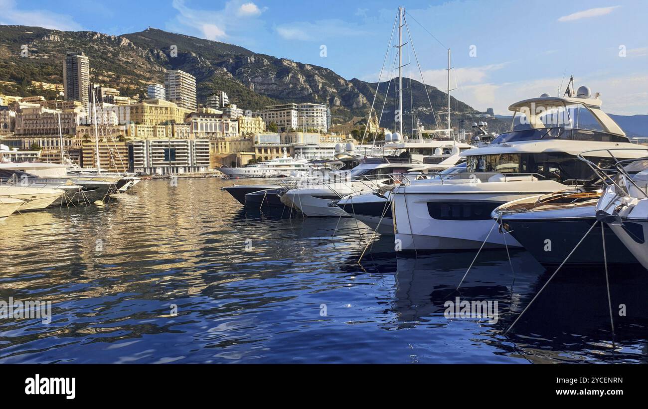 Incredibile paesaggio di barche nel porto di Hercule nel Principato di Monaco, dietro gli edifici di Monte Carlo e altri quartieri. Alba gialla! Foto Stock