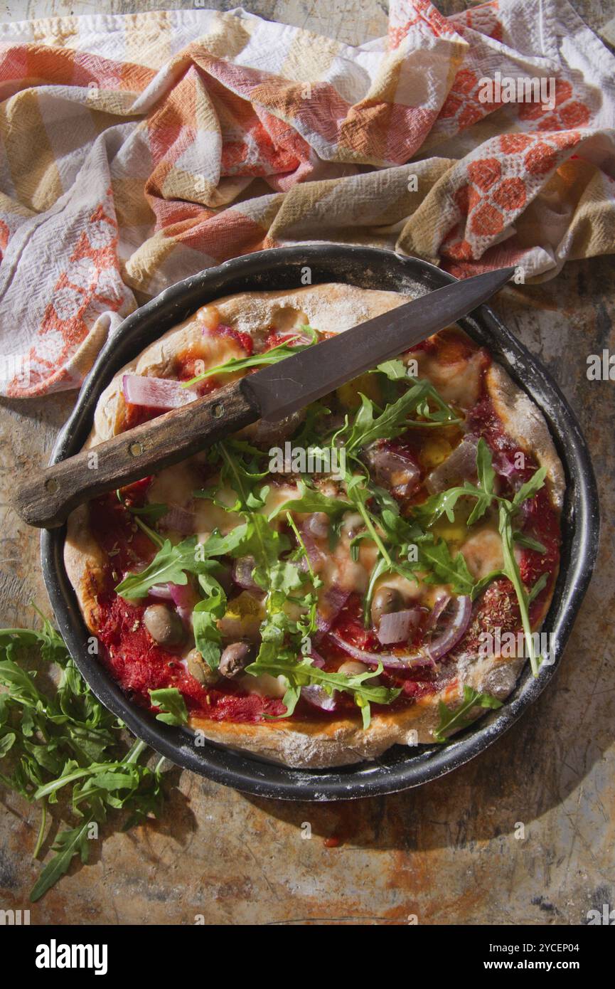 Base per pizza con farina integrale con rucola e cipolla Foto Stock