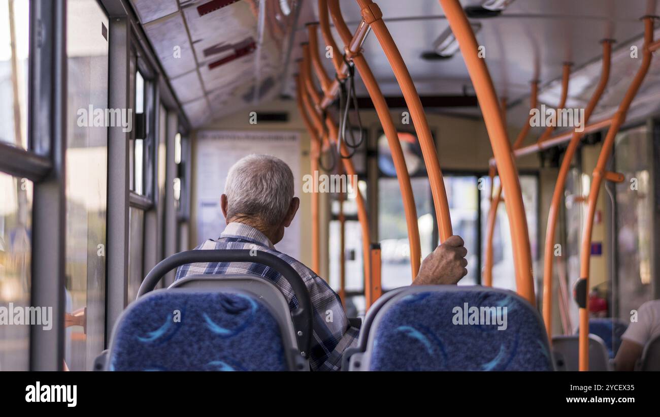 Un uomo anziano su un autobus, rivolto verso la sua direzione Foto Stock