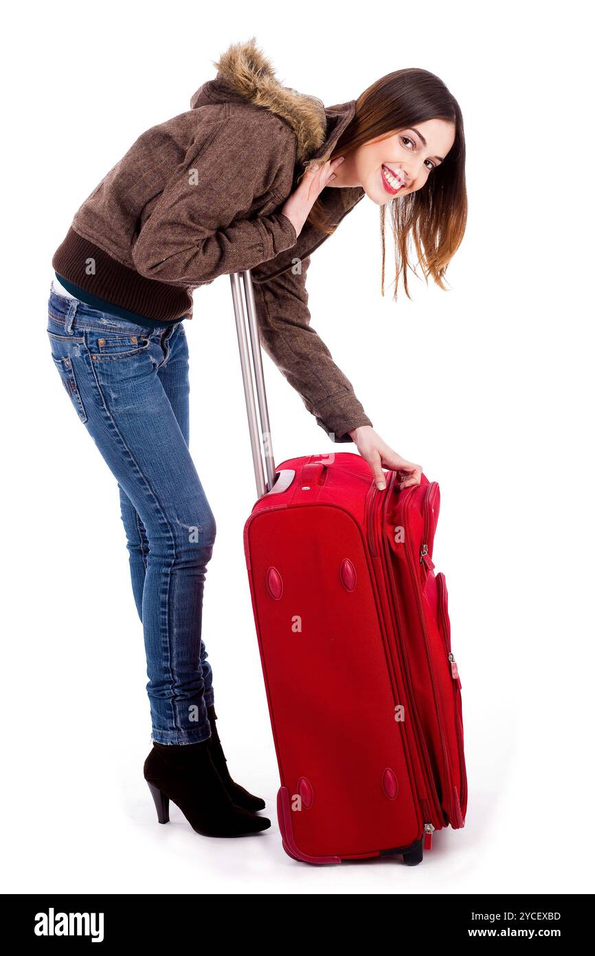 Giovane donna che posa mentre sblocca la borsa da viaggio Foto Stock