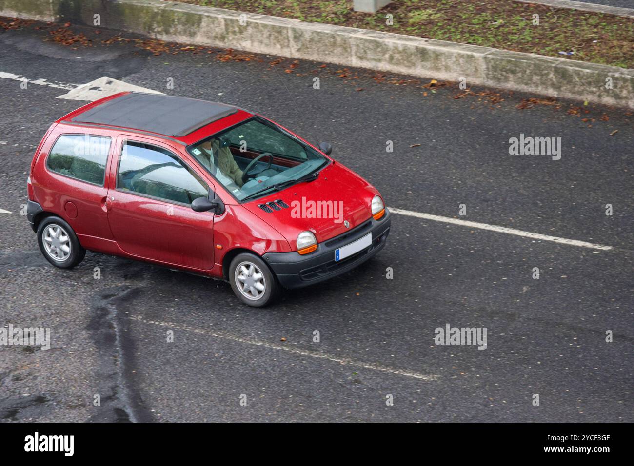 renault twingo rossa con tettuccio apribile aperto, guidata da un uomo in una giornata di sole Foto Stock