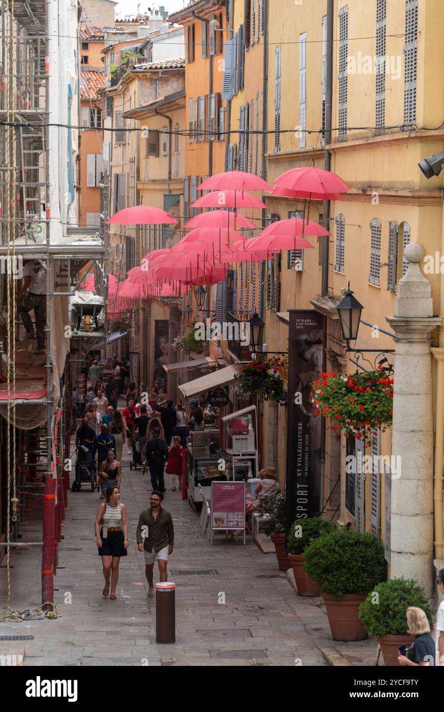 Ombrelli rossi, ombrelli, appesi tra le case nella città dei profumi di Grasse, Provence-Alpes-Cote d'Azur, Francia Foto Stock