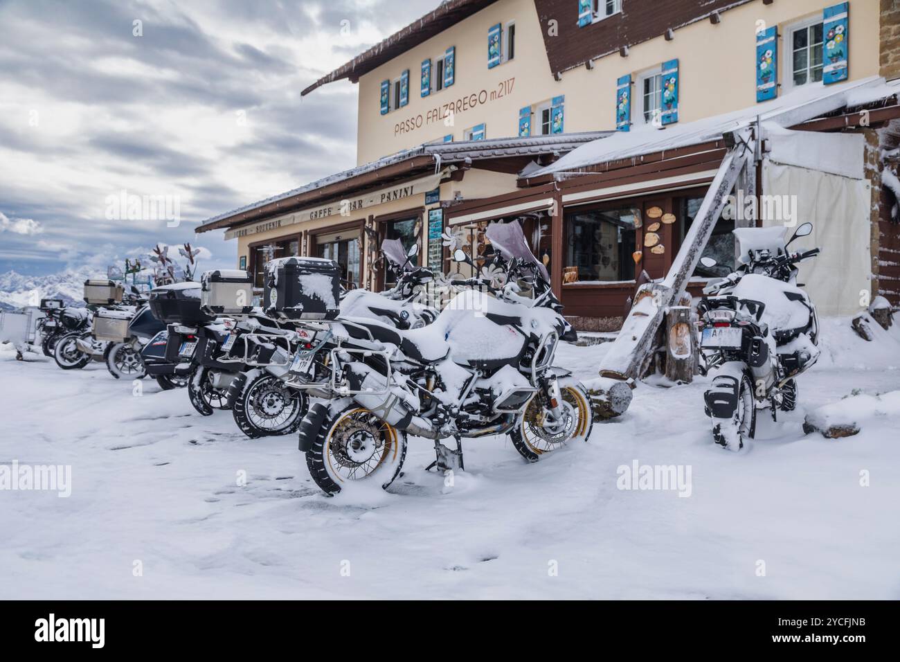 Italia, Veneto, provincia di Belluno, passo Falzarego, gruppo di motociclette innevate parcheggiate su un passo di montagna, una tempesta di neve improvvisa ha impedito ai motociclisti di proseguire il loro viaggio nelle Dolomiti Foto Stock
