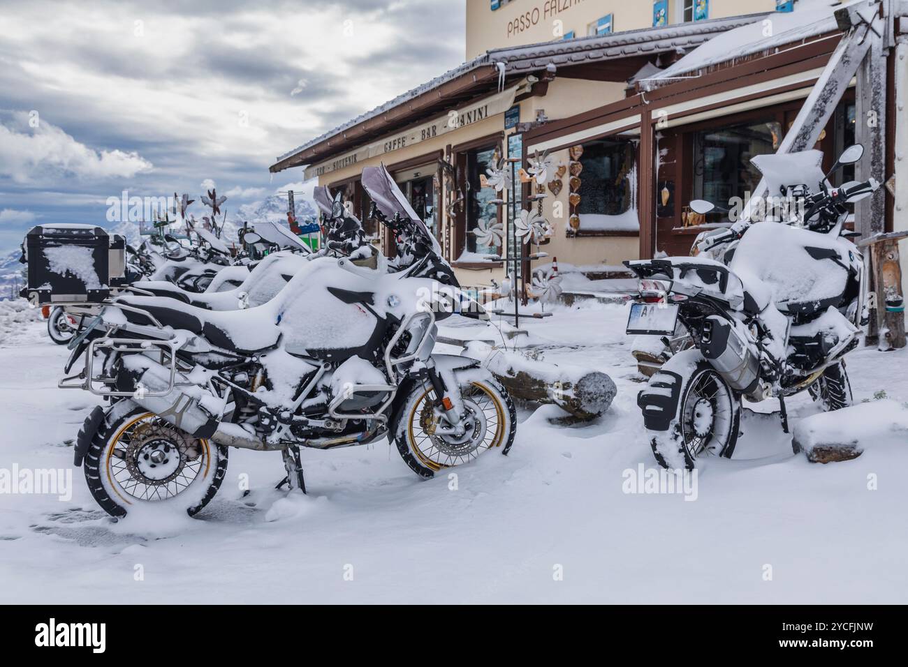 Italia, Veneto, provincia di Belluno, passo Falzarego, gruppo di motociclette innevate parcheggiate su un passo di montagna, una tempesta di neve improvvisa ha impedito ai motociclisti di proseguire il loro viaggio nelle Dolomiti Foto Stock