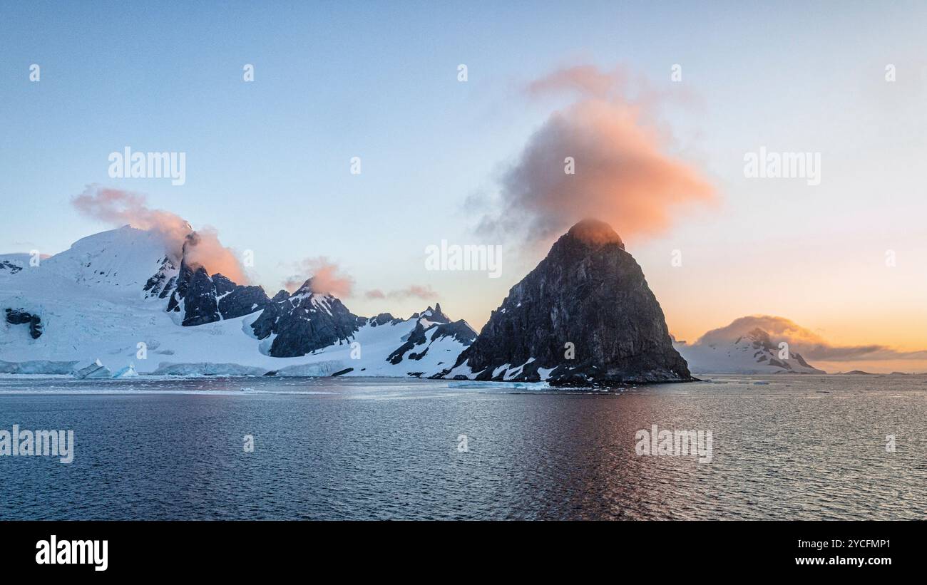 Nuvola rossa luminosa sopra un picco di montagna sulla costa antartica. Baia di Börgen, Penisola Antartica, Antartide. Foto Stock