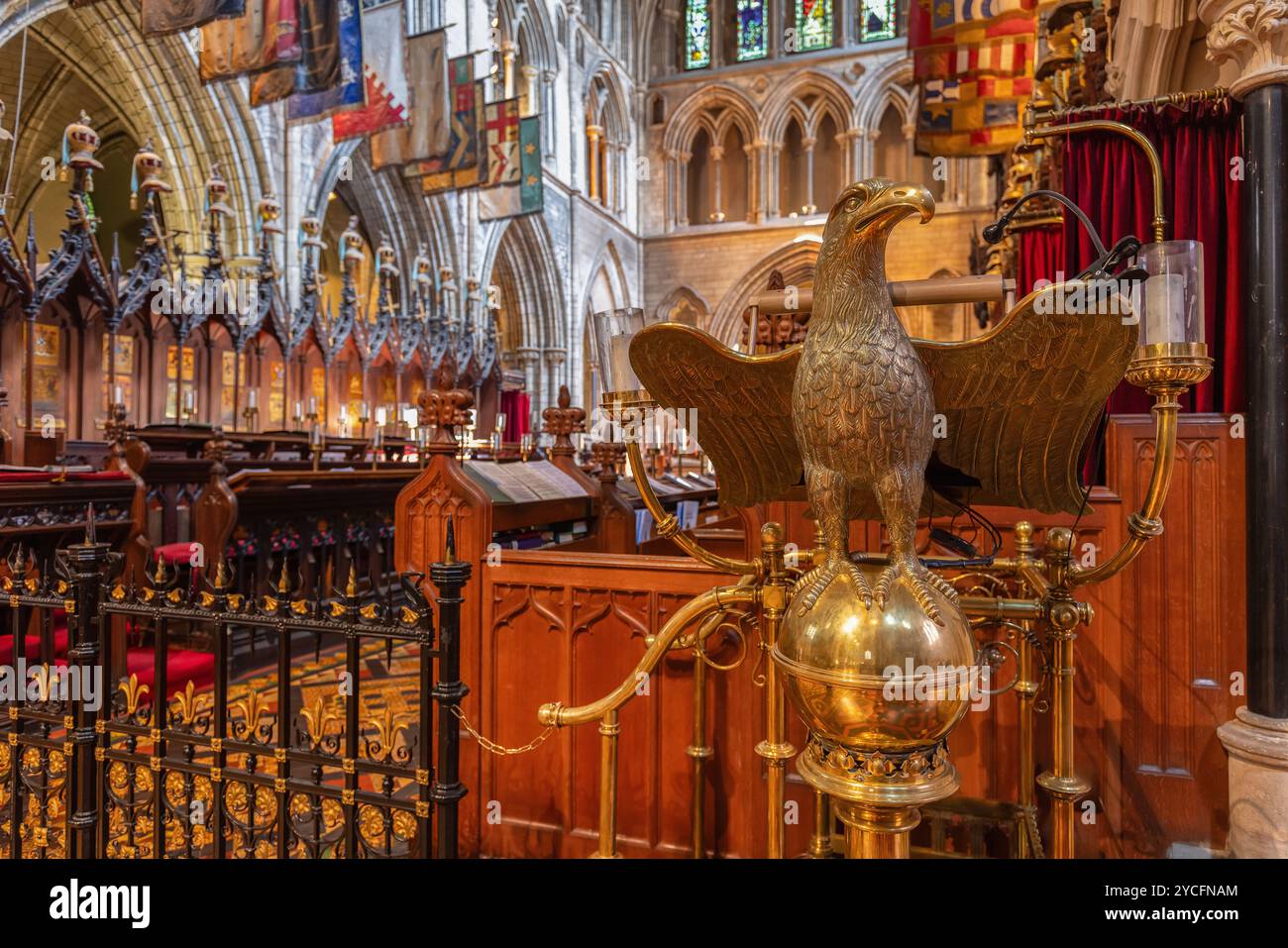 Un primo piano del leggio dell'aquila dorata nella cattedrale di San Patrizio, Dublino, con le sue ali spalmate. Lo sfondo mostra la a gotica del coro Foto Stock