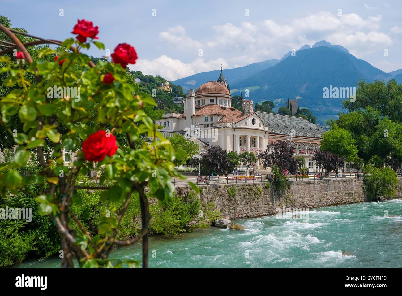 Merano, alto Adige, Italia, Kurhaus sul fiume Passer, sul lungomare di Passer nel centro storico. Davanti, rose rosse sul ponte termale. Foto Stock