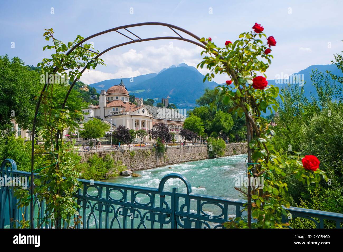 Merano, alto Adige, Italia, Kurhaus sul fiume Passer, sul lungomare di Passer nel centro storico. Davanti, rose rosse sul ponte termale. Foto Stock