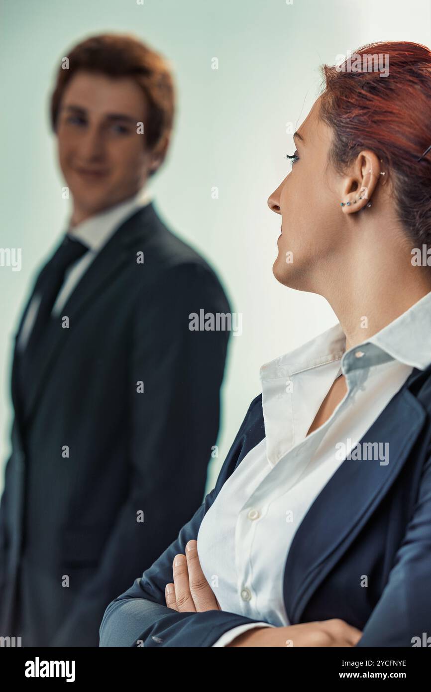 Donna d'affari sicura e uomo d'affari sorridente in un ufficio formale, che incarna il successo e il lavoro di squadra Foto Stock