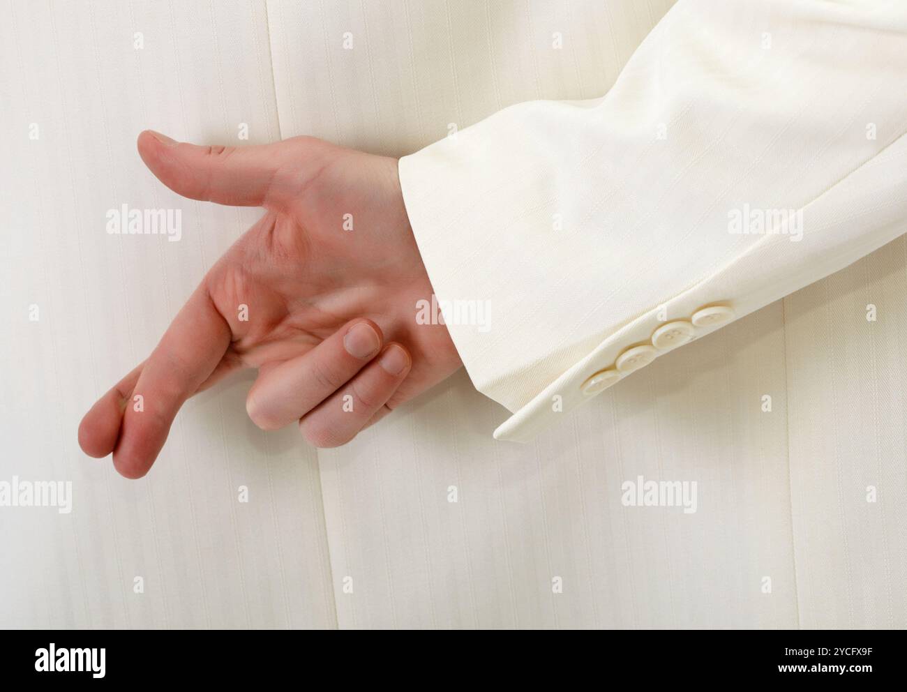 Dita incrociate dietro la schiena - vestito bianco Foto Stock