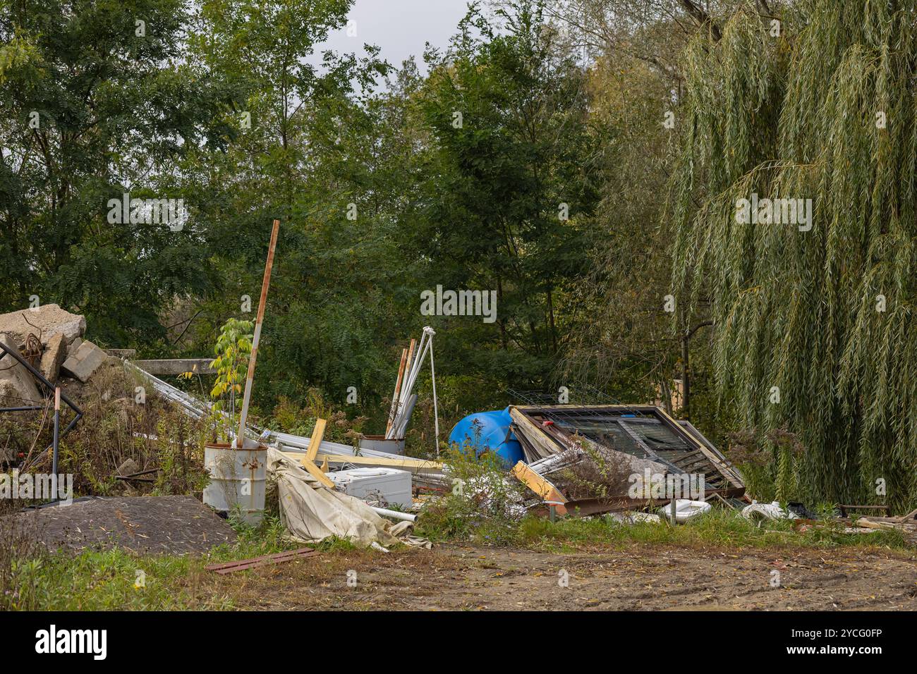 Cumulo di rottami metallici e detriti da costruzione in un'area boschiva in una giornata ricoperta. Concetto di inquinamento ambientale e materiali da costruzione Foto Stock