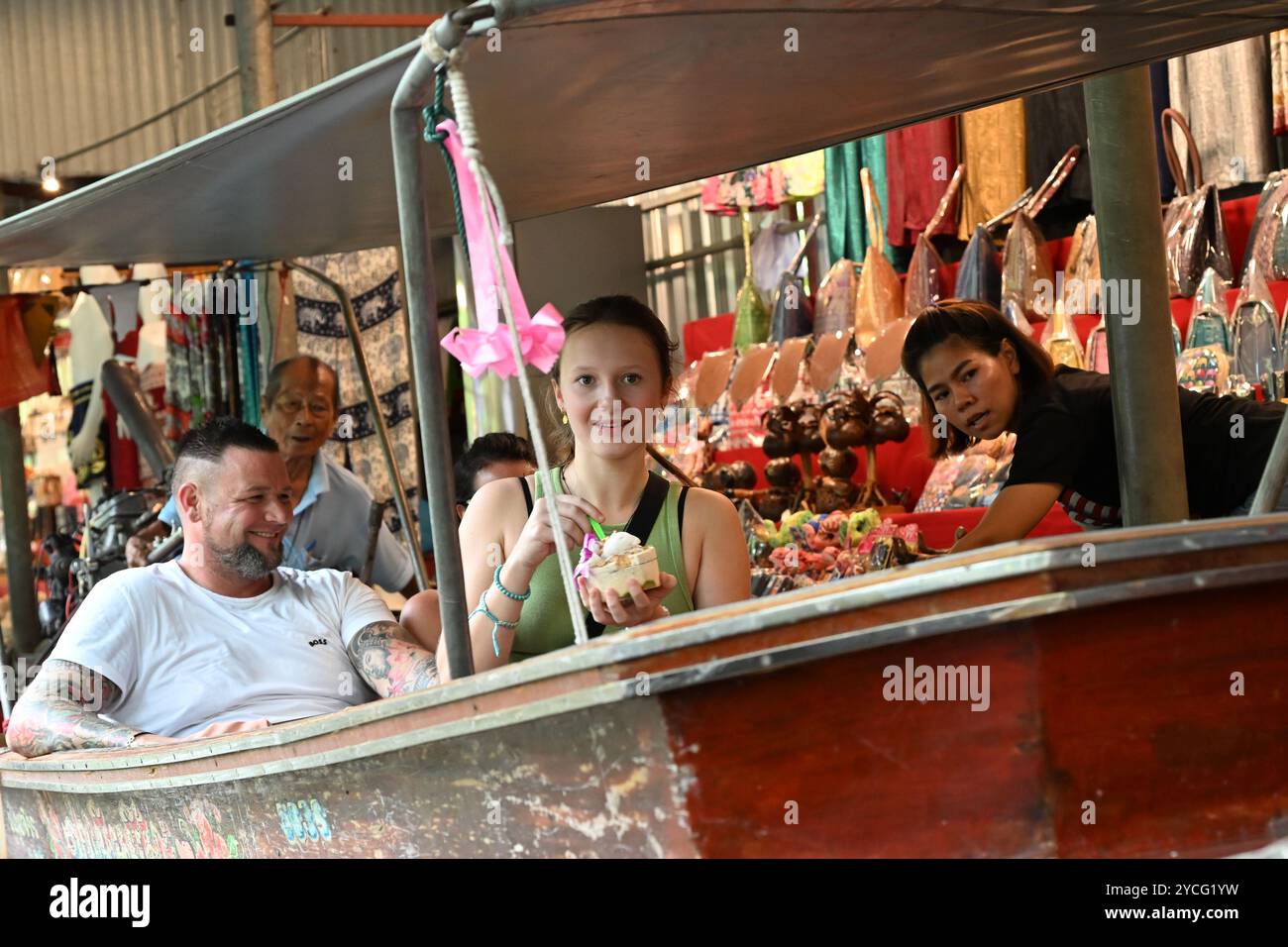 I turisti del 'mercato galleggiante Tailandia' si godono un giro in barca, un gelato di cocco e lo shopping nel damneon saduak Tailandia Bangkok Asia Foto Stock