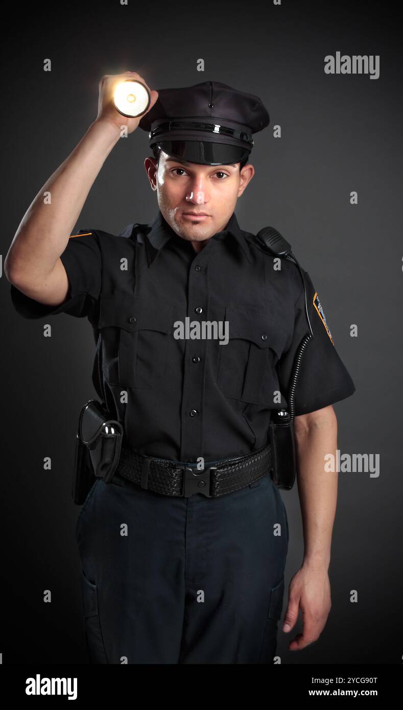 Poliziotto o guardia di sicurezza che sprigiona una torcia Foto Stock