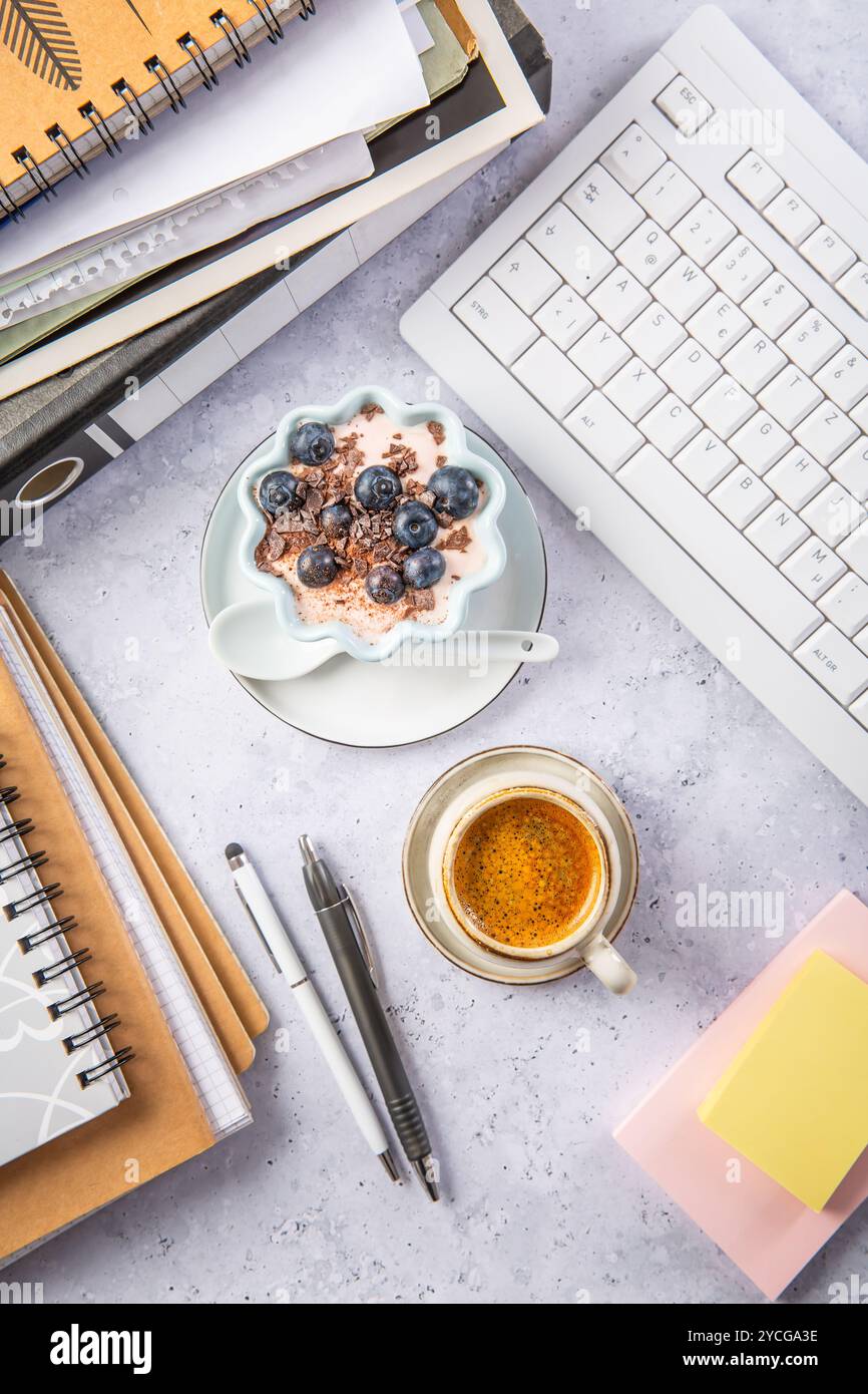 Pausa ufficio con caffè e yogurt sano con mirtilli Foto Stock