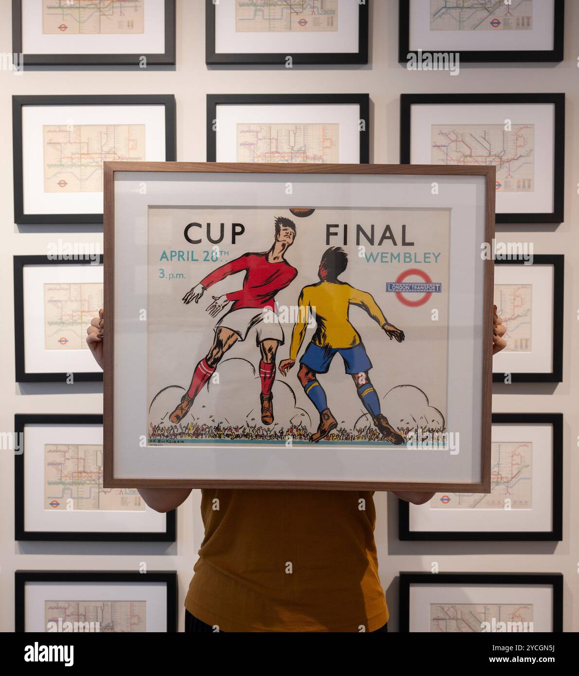 Londra, Regno Unito. 23 ottobre 2024. The Map House presenta la nuova mostra Mapping the Tube: 1863-2023 che esplora l'evoluzione del sistema della metropolitana di Londra e l'iconica mappa della metropolitana di Londra in 160 anni e offre una rara opportunità di vedere e acquistare manoscritti disegnati e annotati a mano da Harry Beck nel 50° anniversario della sua morte. La mappa tascabile di Beck del 1933 ha influenzato la progettazione delle mappe dei trasporti in tutto il mondo. La mostra si svolge dal 25 ottobre al 30 novembre 2024. Immagine: Poster della finale di Wembley Cup, 1934, contro un muro di mappe sotterranee triplicate. Crediti: Malcolm Park/Alamy Live News Foto Stock