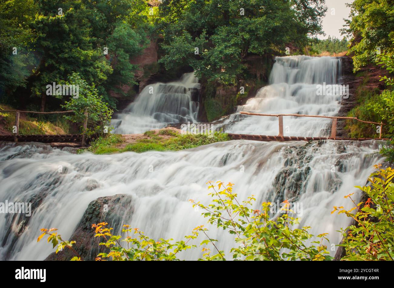 Serene cascate: Una tranquilla cascata circondata da una vegetazione lussureggiante. Foto Stock