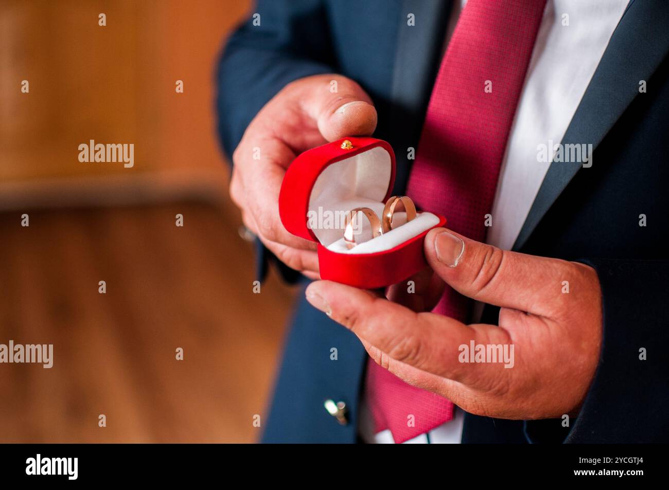 Elegante presentazione di anelli nuziali in una lussuosa scatola di velluto rosso. Foto Stock