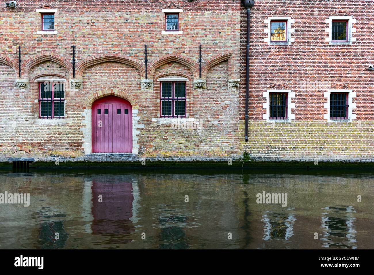 Edifici medievali in mattoni che costeggiano il canale Gronerei e il loro riflesso. Bruges, Belgio Foto Stock