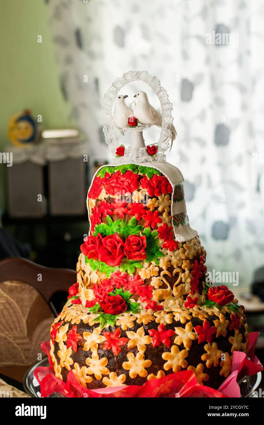 Elegante torta nuziale con decorazioni floreali e dove Topper. Foto Stock