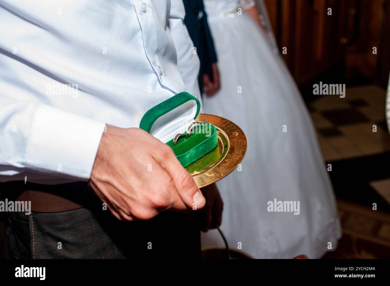 Elegante cerimonia nuziale con piatto d'oro tradizionale e scatola di velluto verde. Foto Stock