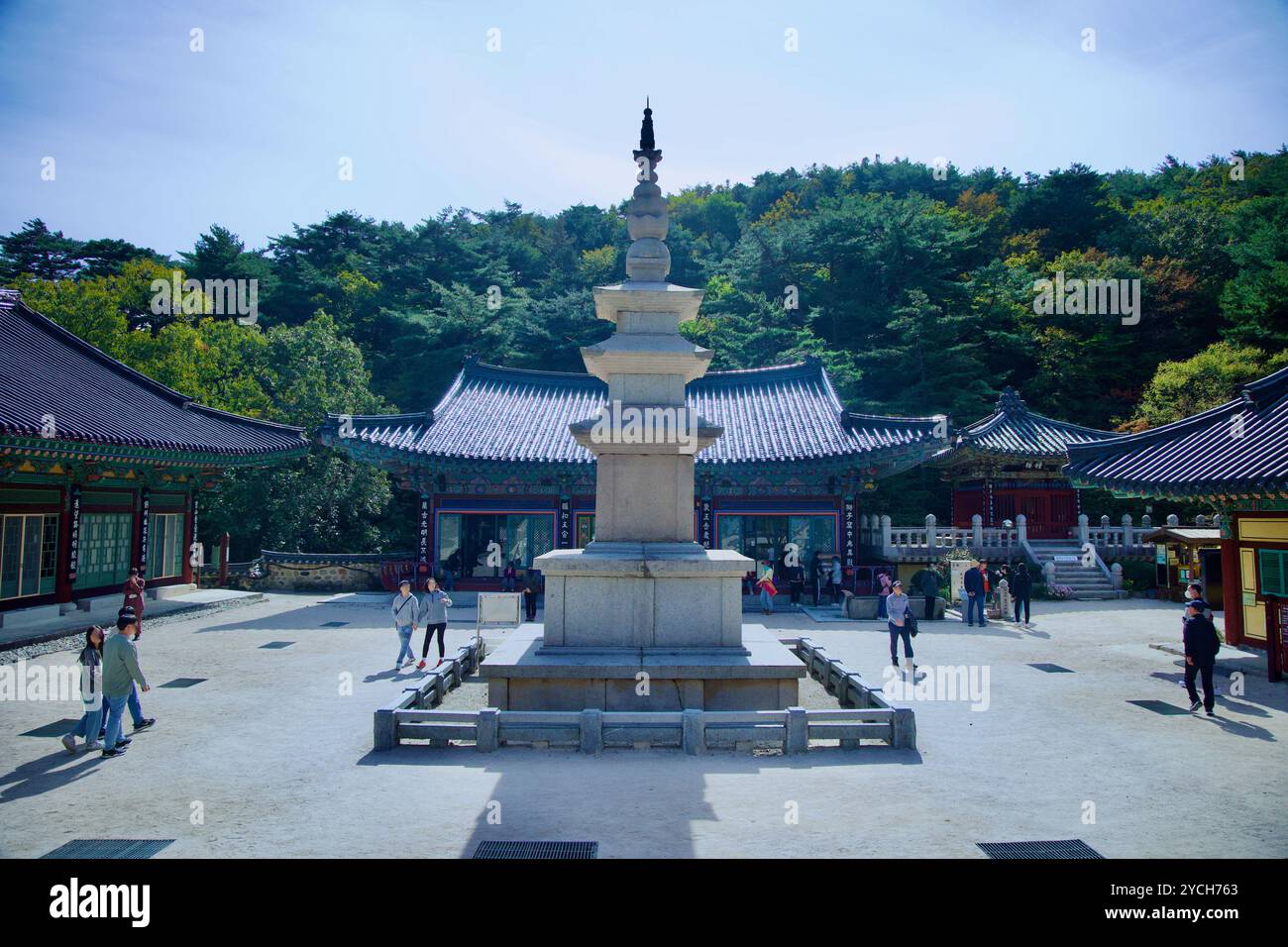 Ulsan, Corea del Sud - 22 ottobre 2023: Una pagoda in pietra si erge in modo prominente nel cortile del Tempio di Seoknamsa, circondato da edifici tradizionali A. Foto Stock