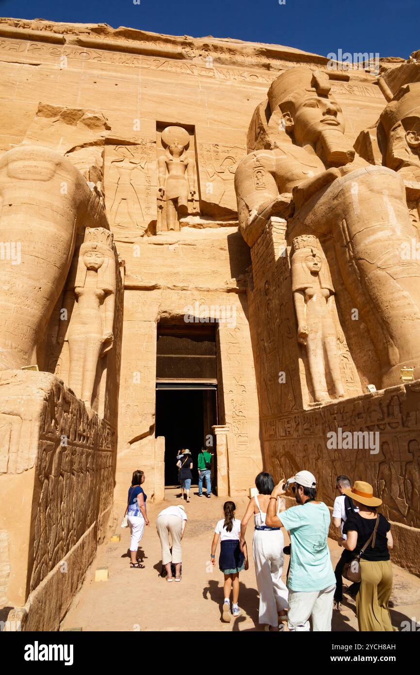 Turisti all'ingresso del grande Tempio di Ramses II, scavato nella roccia, ad Abu Simbel, Assuan, Egitto. Foto Stock