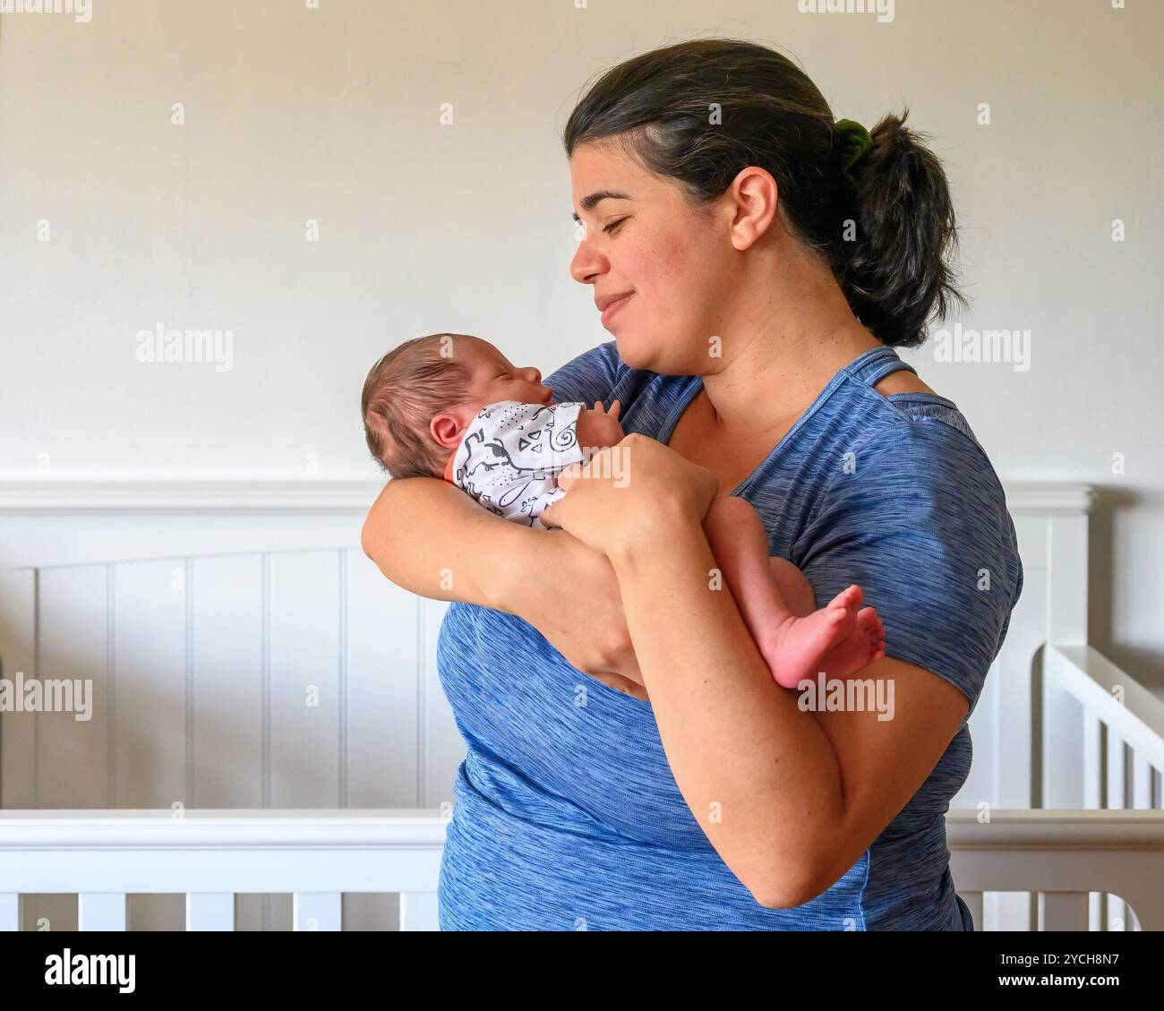 Una madre che tiene il suo bambino in un autentico ritratto di stile di vita. Foto Stock