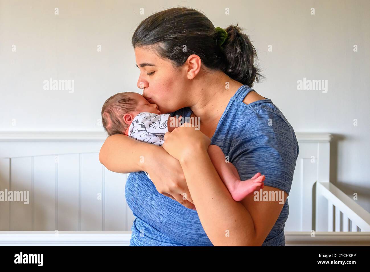 Una madre che tiene il suo bambino in un autentico ritratto di stile di vita. Foto Stock