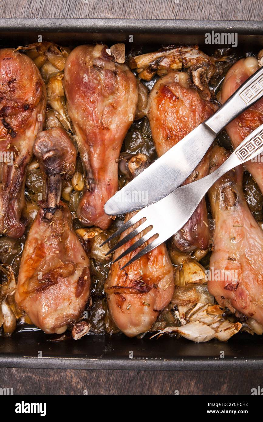Cosce di pollo cotte in vassoio su legno nero Foto Stock