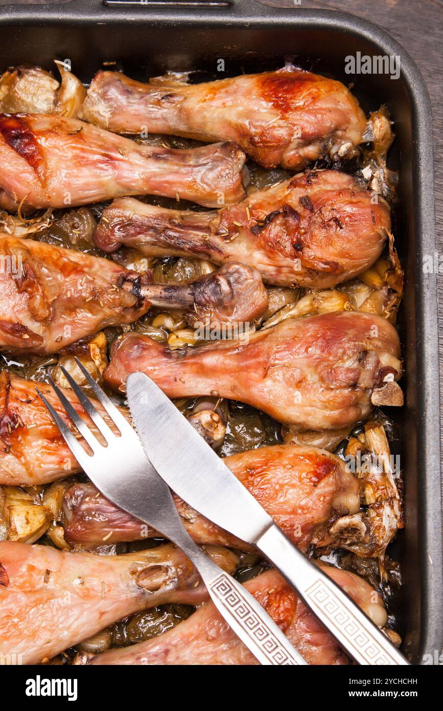 Cosce di pollo cotte in vassoio su legno nero Foto Stock
