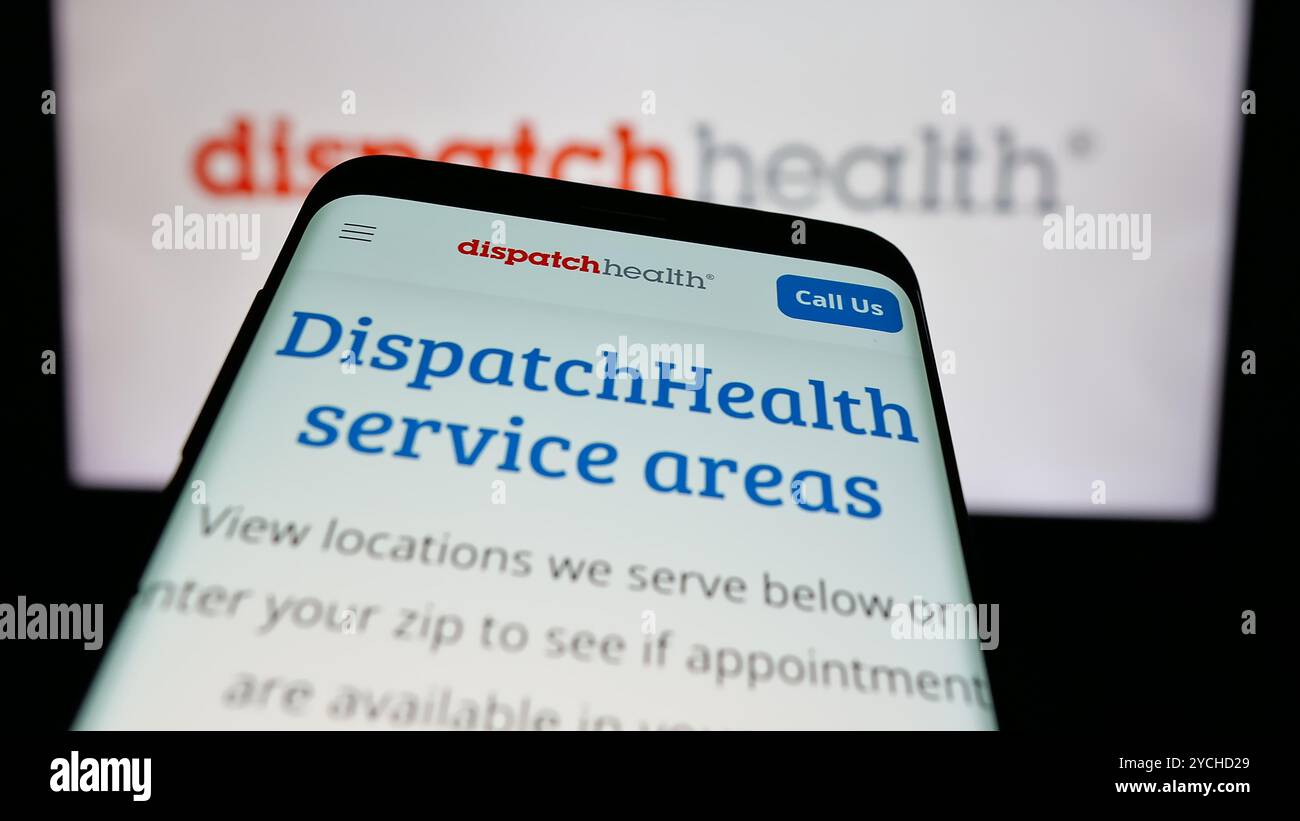 Telefono cellulare con sito web della società statunitense DispatchHealth Management LLC sullo schermo davanti al logo aziendale. Mettere a fuoco in alto a sinistra sul display del telefono. Foto Stock