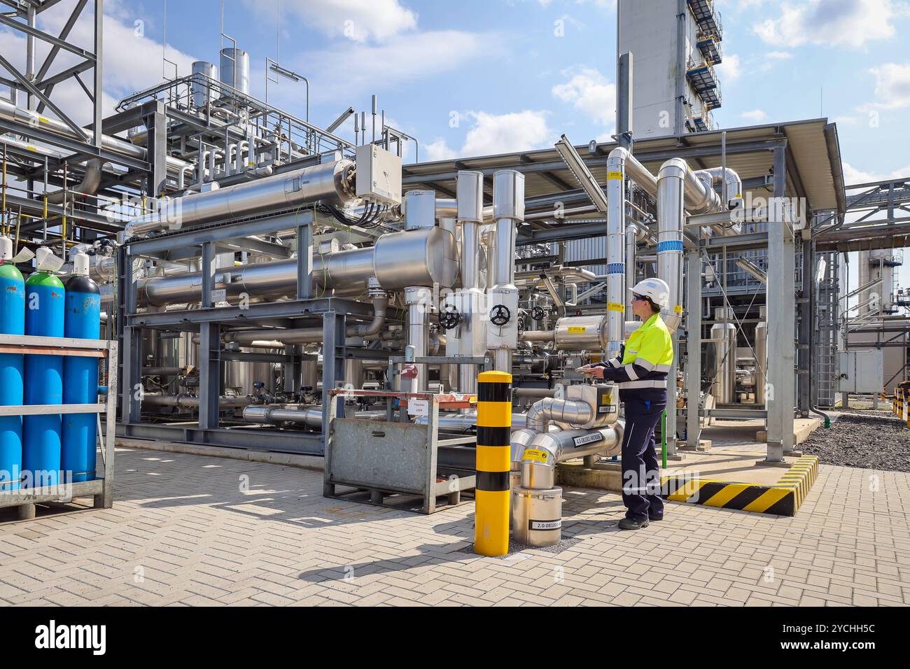 Oberhausen, Nordrhein-Westfalen, Deutschland - Gruener Wasserstoff bei Air liquide, Wasserstoffproduktion im Chemiepark OQ Chemicals. TRAILBLAZER, ein 20 MW-Elektrolyseur zur Herstellung von gruenem, klimaneutralem Wasserstoff. Eine Ingenieurin regelt un einem Schieberventil den Leitungsdurchfluss. Oberhausen Nordrhein-Westfalen Deutschland *** Oberhausen, Renania settentrionale-Vestfalia, Germania idrogeno verde presso Air liquide, produzione di idrogeno presso il parco chimico OQ Chemicals TRAILBLAZER, un elettrolizzatore da 20 MW per la produzione di idrogeno verde e climaticamente neutro un ingegnere regola il flusso della linea Foto Stock