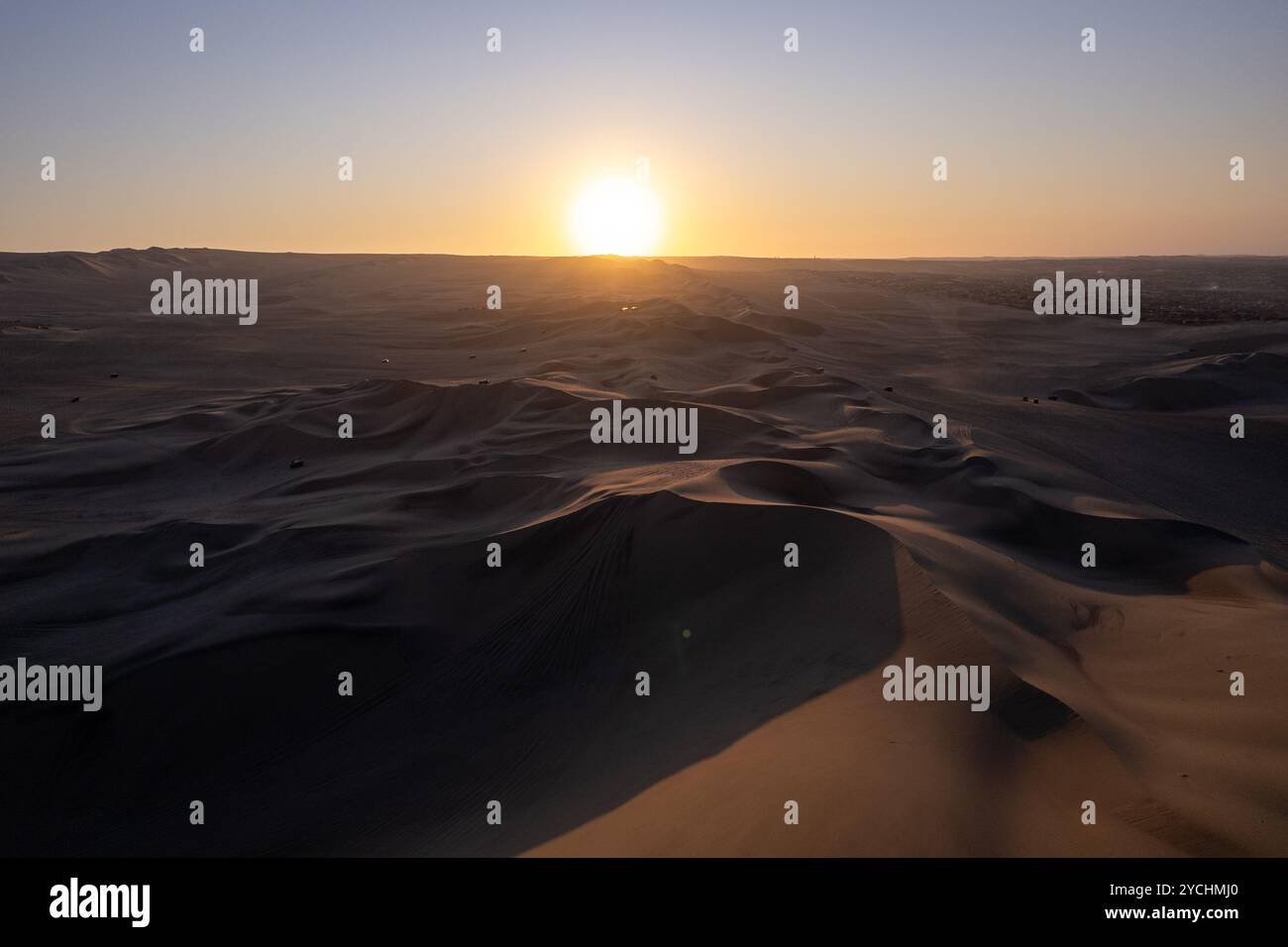 Immenso paesaggio delle dune vicino alla città di Ica, Perù al tramonto di fronte al Sole Foto Stock