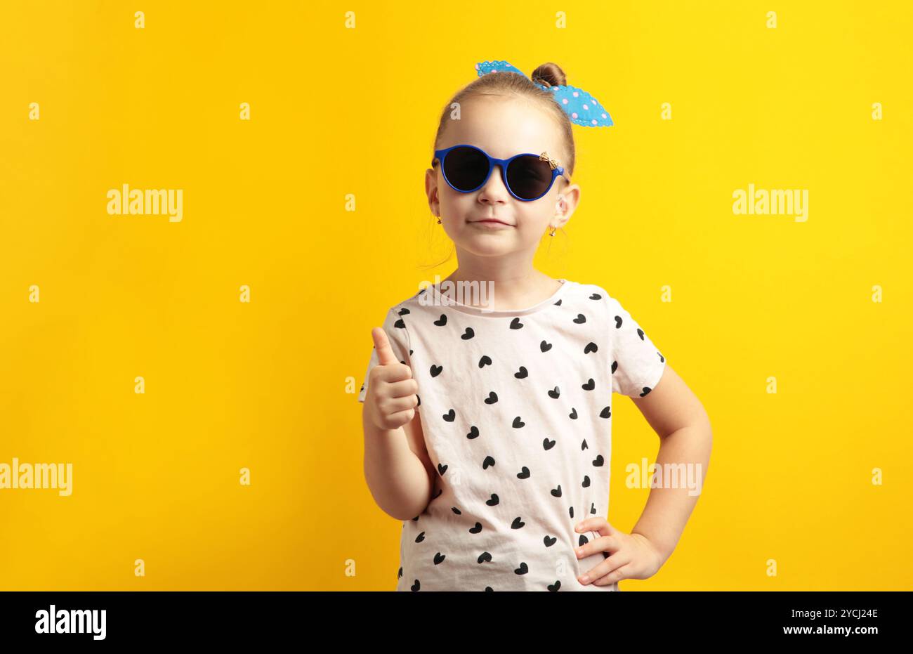 Foto di una giovane ragazza allegra e felice che fa sorridere le dita con il pollice su sfondo giallo. Vista dall'alto Foto Stock