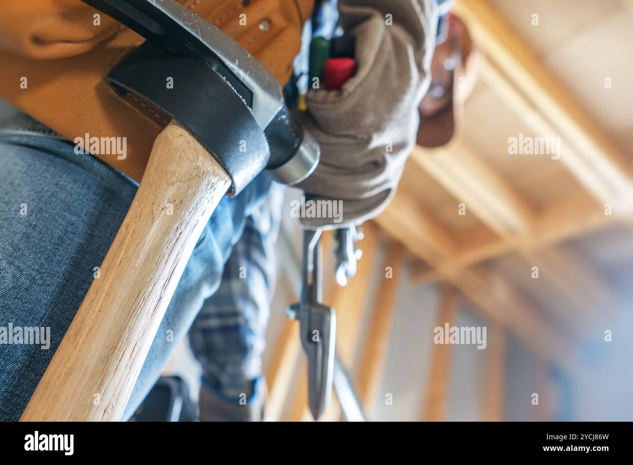 Un falegname esperto utilizza utensili manuali, concentrati sulla sua maestria artigianale in un ambiente di lavoro ben illuminato durante il giorno. Foto Stock